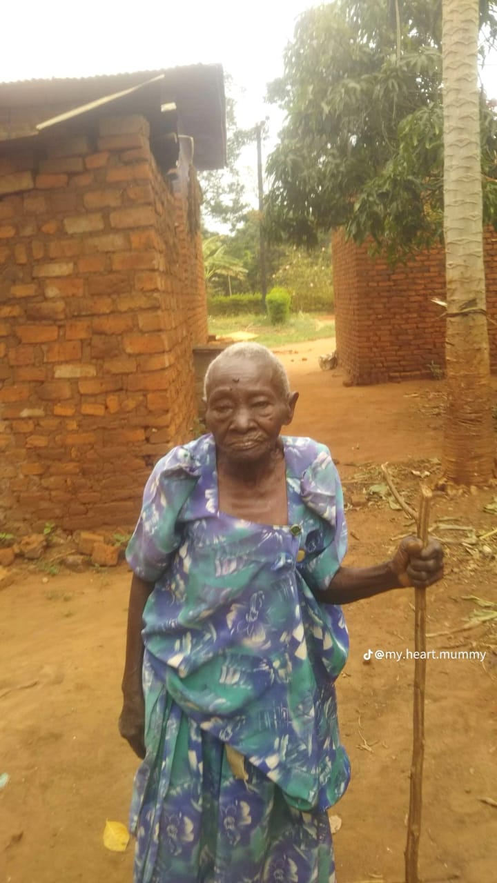 Bweguyibwe Catherine standing outside her home in Uganda